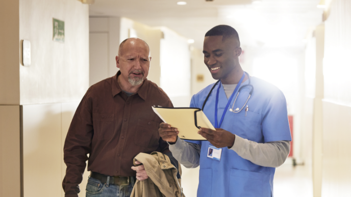 Medical staff reading chart to patient while walking
