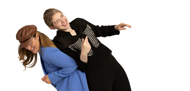 Two individuals joyfully laughing with one person leaning on the other