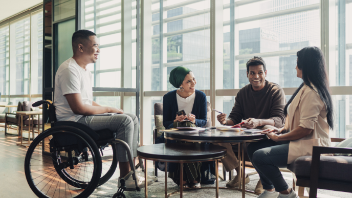 Four people sitting around table talking