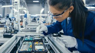 Individual with gloves and safety glasses as they work in the semiconductor industry