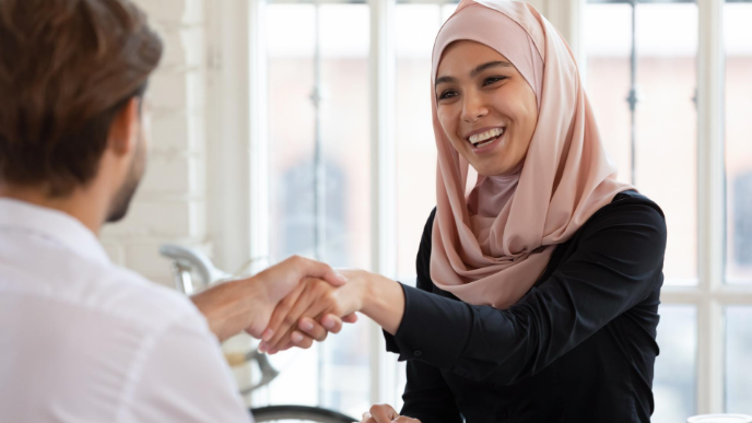 Women in hijab shaking hands