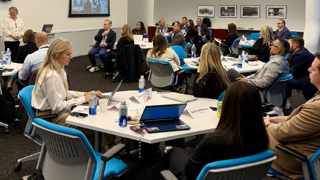 group of people sat around tables at a conference
