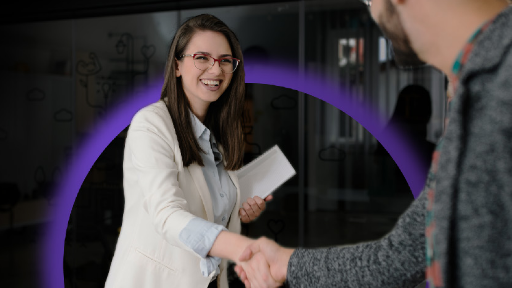 Woman holding document shaking another person's hand