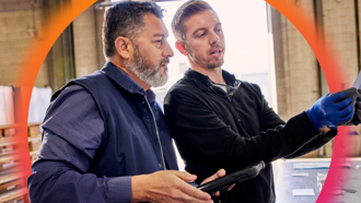Two individuals in manufacturing industry in front of Cielo orange glow
