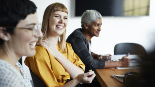 three professionals talking in a conference room